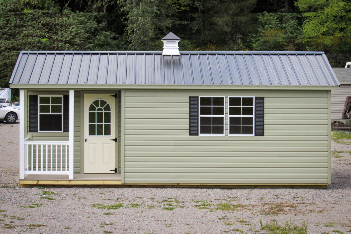 green 8x12 cabin with cupola, windows, and white door