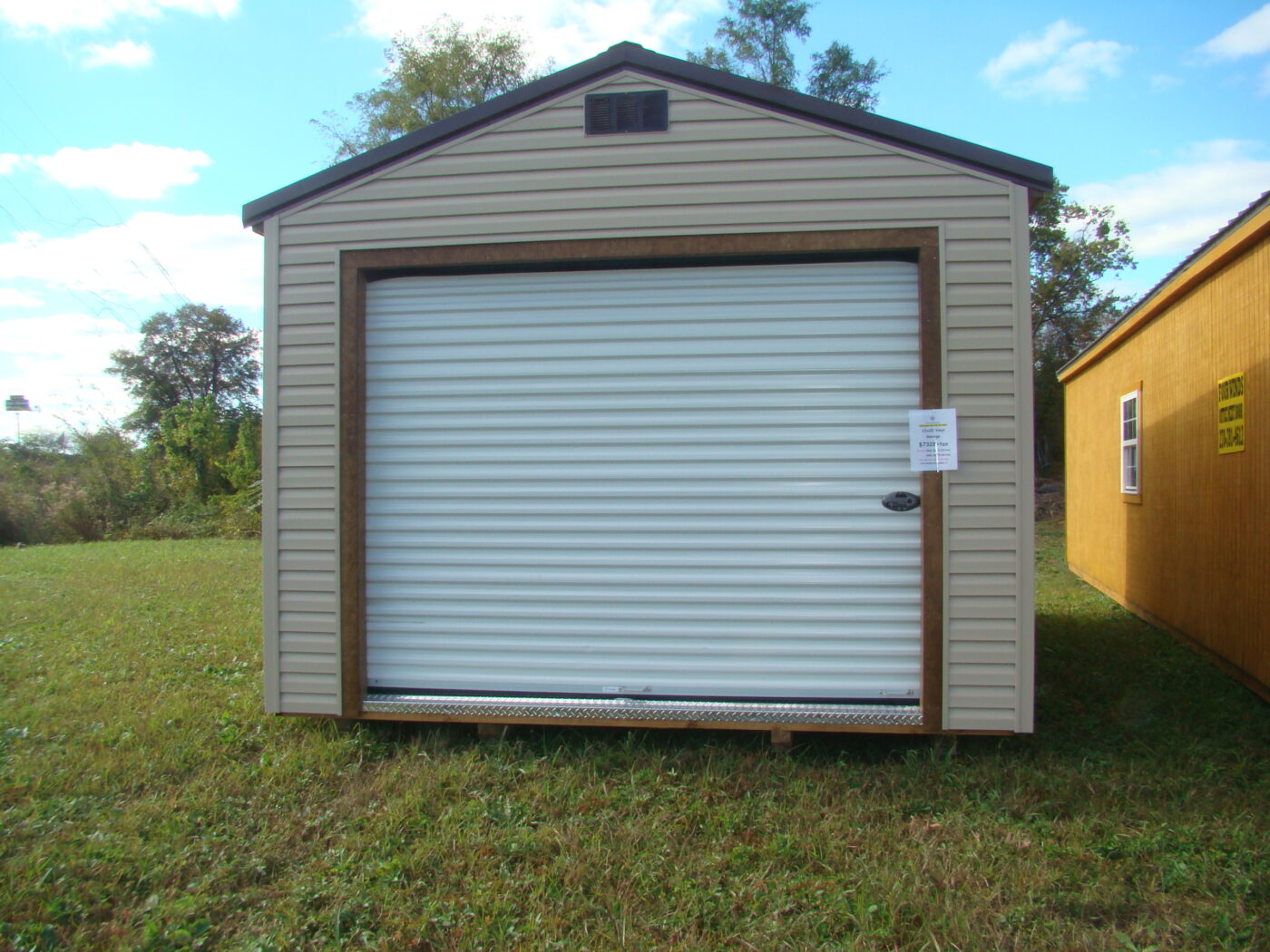 tan 12x20 vinyl ranch garage with wood trim and black roof