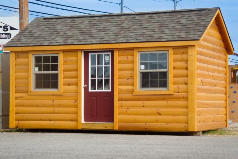 wooden 8x10 cabin wit gray roof, two windows, and a red door
